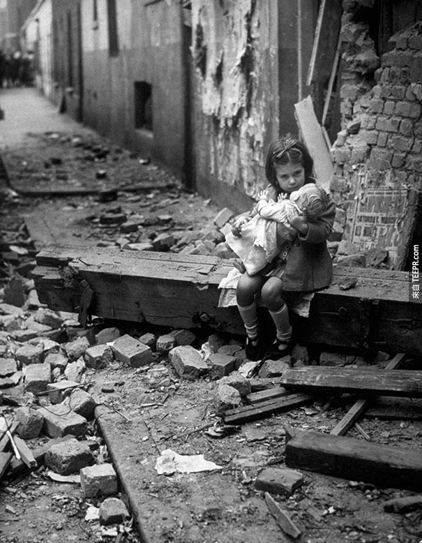 小女孩跟他的玩偶坐在被炸毁的家中 - 伦敦 1940