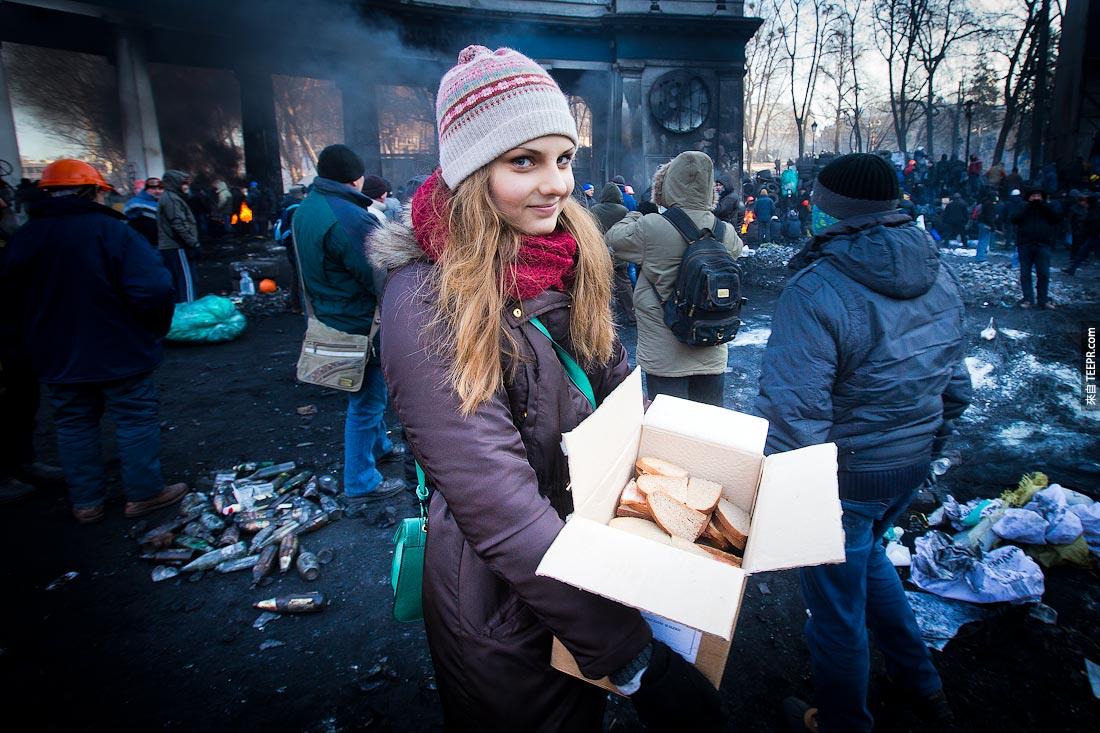 一名每少女把三明治送给示威的群众 (乌克兰 2013)