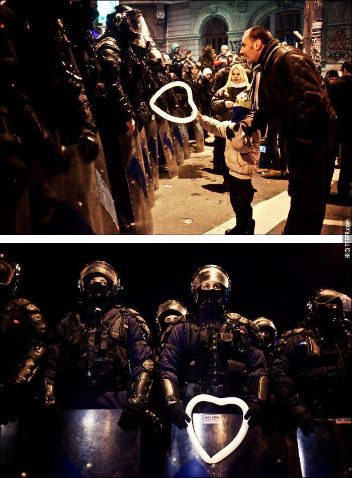一名年亲的小男生送了一个心型的气球给警察伯伯 (布加勒斯特，罗马尼亚 2012)。
