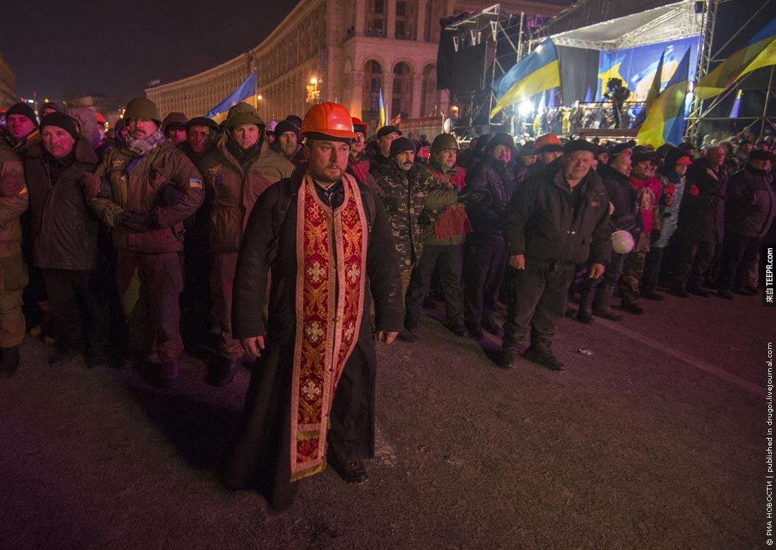 一名勇敢的的牧师挡在示威者跟警察中间 (基辅，乌克兰 2013)