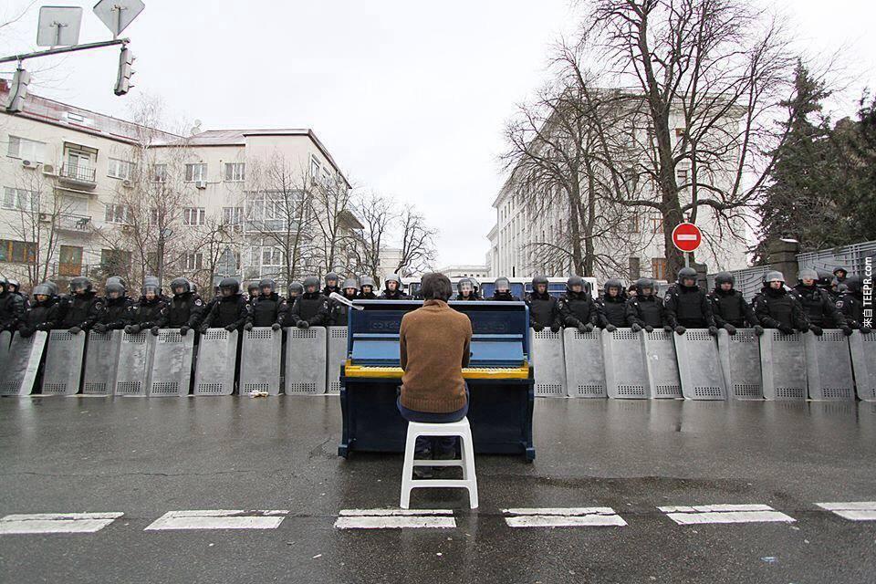 一名男子为了警察弹奏钢琴 (基辅，乌克兰 2013)