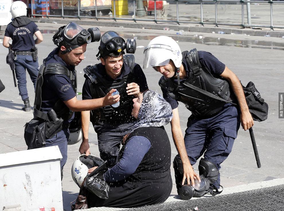 防暴警察们帮助一名受到催泪瓦斯影响的女士。 (安卡拉，土耳其 2013)