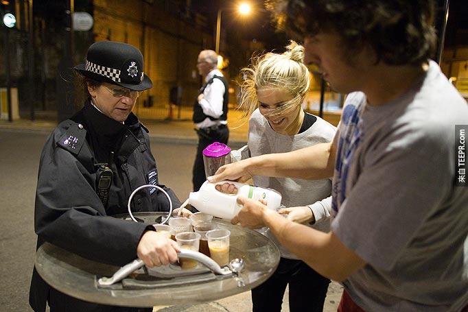 英国的好市民关怀着管制示威人群的警察 (伦敦，英国 2011)。