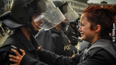 防暴警察跟一名示威者一起哭泣 (索非亚，保加利亚 2013）。
