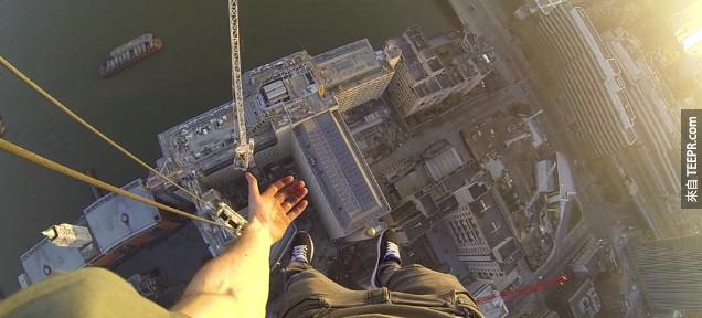 Guy jumps over huge gap to hang 490-feet above London with one hand
