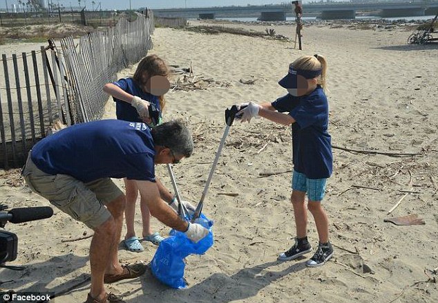 Mr El-Erian described his work-life balance being 'out of whack' - so he resigned from PIMCO to spend more time with his wife and daughter. He is pictured in 2011 helping clean up the Orange County coastline with a volunteers as part of PIMCO project