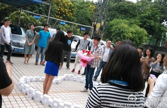 中國男子買了99部iPhone 6，手上還抱著一束玫瑰花向女友求婚。