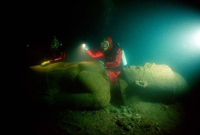 潜入水中的学者正在检查一尊古老的法老王神像。