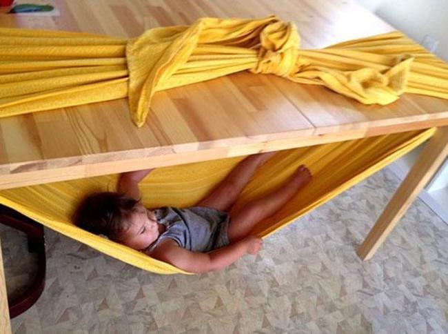 5. 用一条长毯子跟餐桌，就可以为孩子制作一个吊床喔！