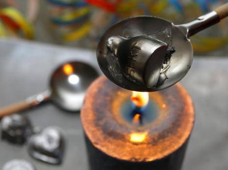 Put one of the lead figurines into the spoon and hold the spoon over the flame to watch it melt into oblivion.