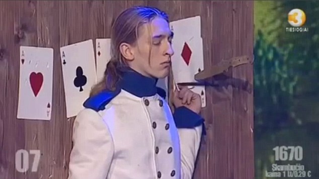 Here he is pictured earlier in the performance when the knife sliced open his left hand as he held up a playing card