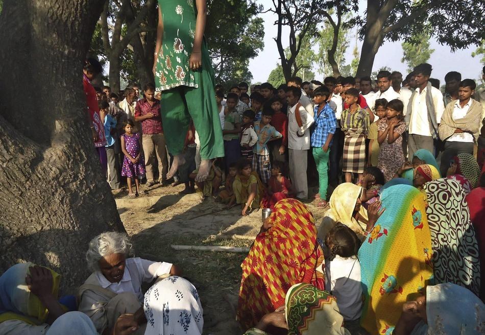 25. 印度的居民聚集在兩具垂掛在樹上的屍體旁邊，據說這兩位12和14歲的小女孩是遭到性侵並殺害。