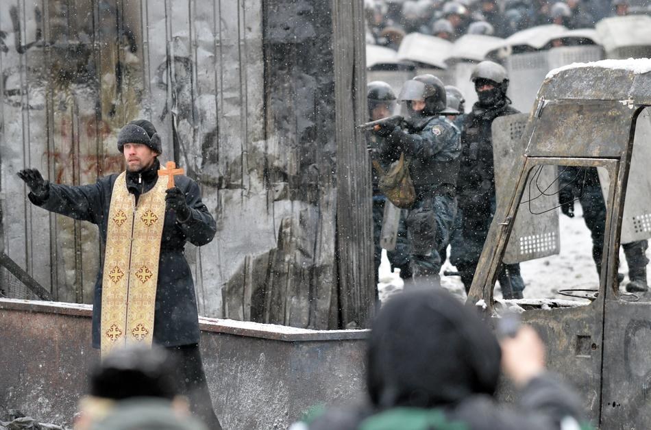 10. 在烏克蘭，一位東正教的牧師站在抗爭者和防暴警察之間，試圖要緩解衝突。