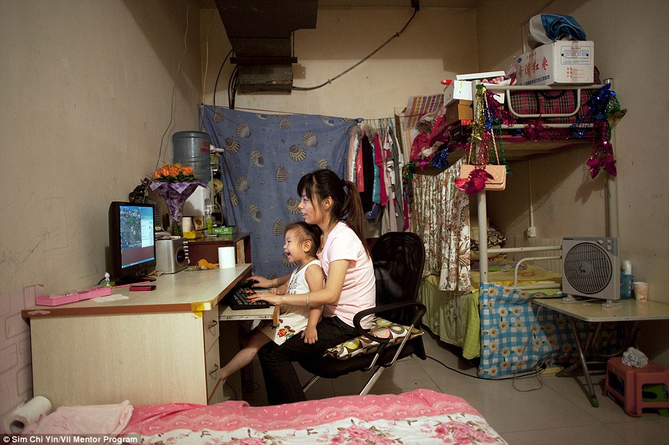 25岁的Ji Lanian和她的3岁女儿正在一间较大的房间里玩电脑。