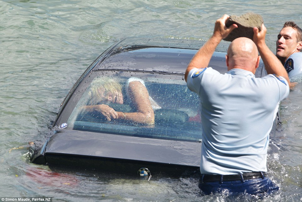 車內的女子可能再晚個一分鐘，就可能面臨溺斃的危機。在這個危及之際，一位員警舉起了大石頭，將車窗砸破。同時，另一位員警正試著將車子撐住，減緩車子沉入水中的速度。