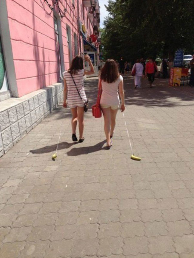 两位女孩正在遛香蕉。