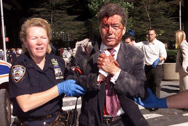 NYPD Officer Moira Smith helps an injured man on the morning of 9/11/2001. Shortly after the photo was taken, she returned to the lobby of the south tower. She was killed ten minutes later when the building collapsed.