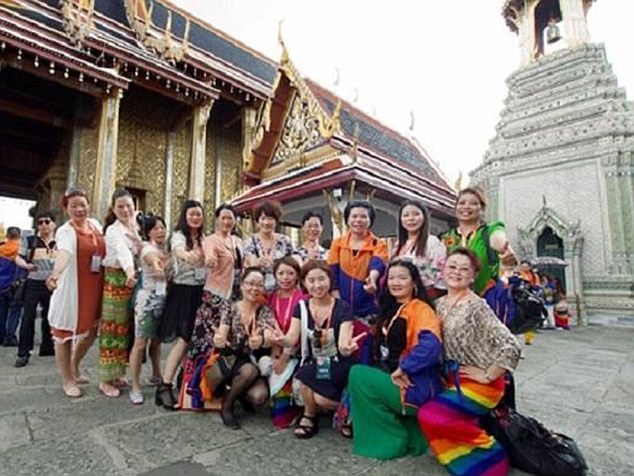 Holiday snap: A small section of the 12,700-person group pose for a picture as they take in the sites while on holiday in Thailand