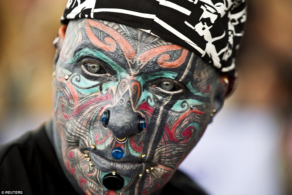 Striking: German tattoo model Magneto - whose entire face, including eyeballs, have been covered in ink - poses for the cameras at this year's Israeli tattoo convention in Tel Aviv