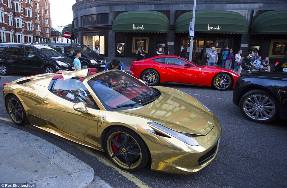 This ostentatious gold Ferrari 458 (front) and a red Ferrari California (back) were seen parked up outside Harrods - a popular spot for the lavish vehicles - as the supercar season gets underway