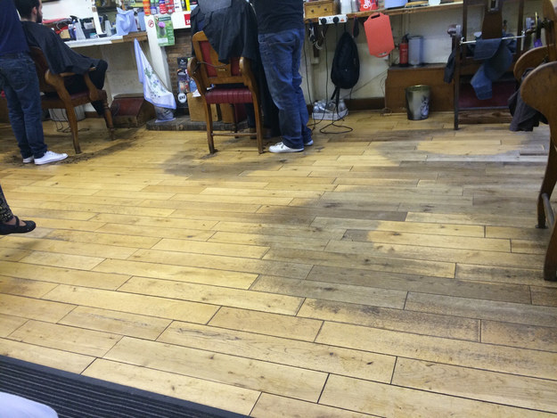 The floor of a barbershop, perfectly worn away over years of work.