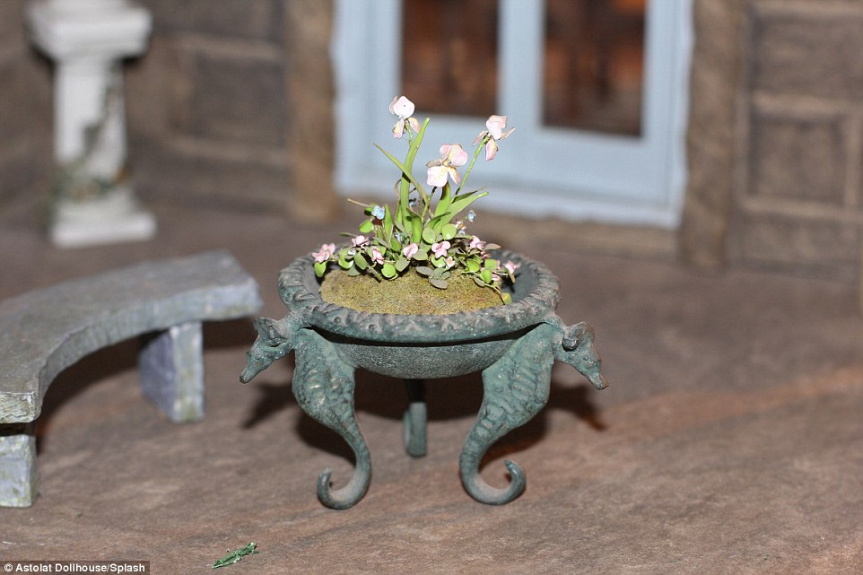 Each leaf and petal of these meticulously crafted orchids was made by hand, as was the chiseled stone plant pot