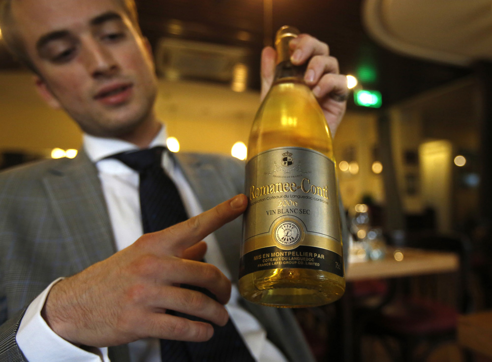 Gaudfroy shows a bottle of fake Romanee-Conti during a photo opportunity for Reuters in Beijing