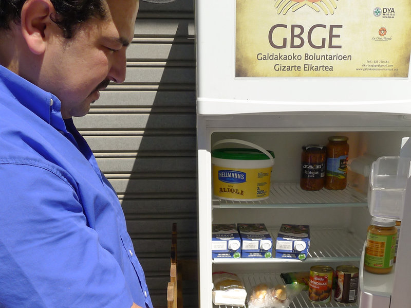 Issam Massaoudi, an unemployed Moroccan immigrant, checks out what's inside the Solidarity Fridge. Massaoudi says money is tight for him, and it's "amazing" to be able to help himself to healthy food from Galdakao's communal refrigerator.