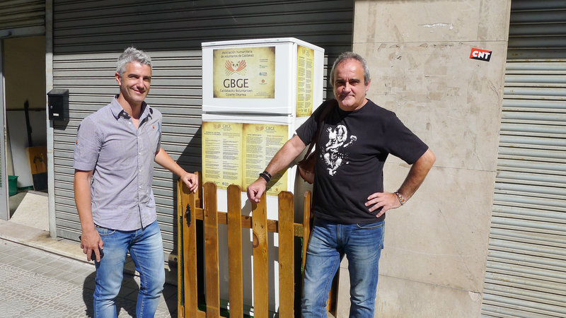 Galdakao Mayor Ibon Uribe (left) and volunteer Javier Goikoetxea pose in front of the Solidarity Fridge, Spain's first communal refrigerator, shared by citizens in Galdakao, a city outside Bilbao.