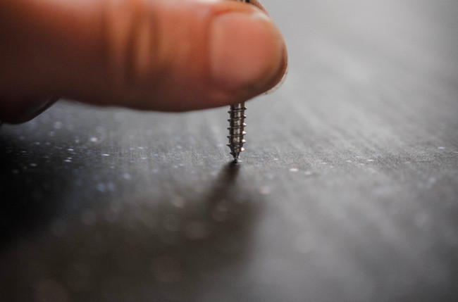 He began experimenting with ways to pierce the paper without creating ragged tears. This screw was an attempt, but he found a pushpin worked the best.