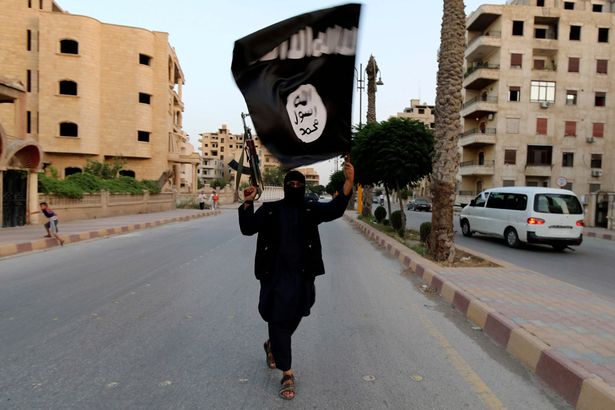 A member loyal to the Islamic State in Iraq and the Levant (ISIL) waves an ISIL flag in Raqqa June 29, 2014