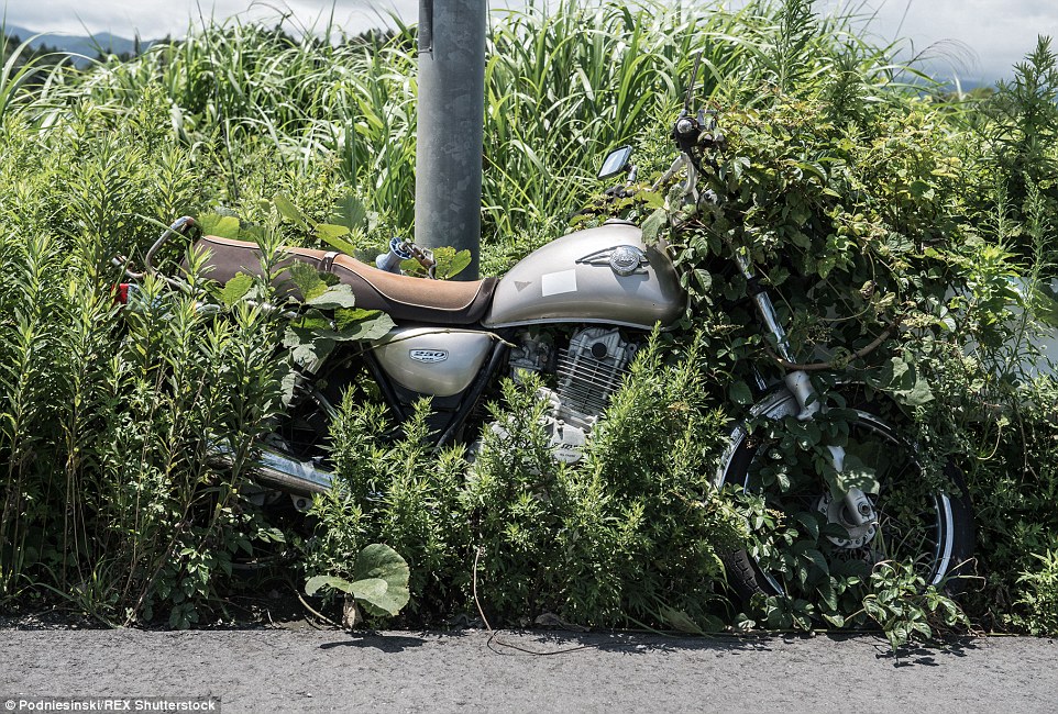 A motorbike sits chained to a pole where it was left locked in the hours before the tsunami struck the region, triggering a reactor meltdown
