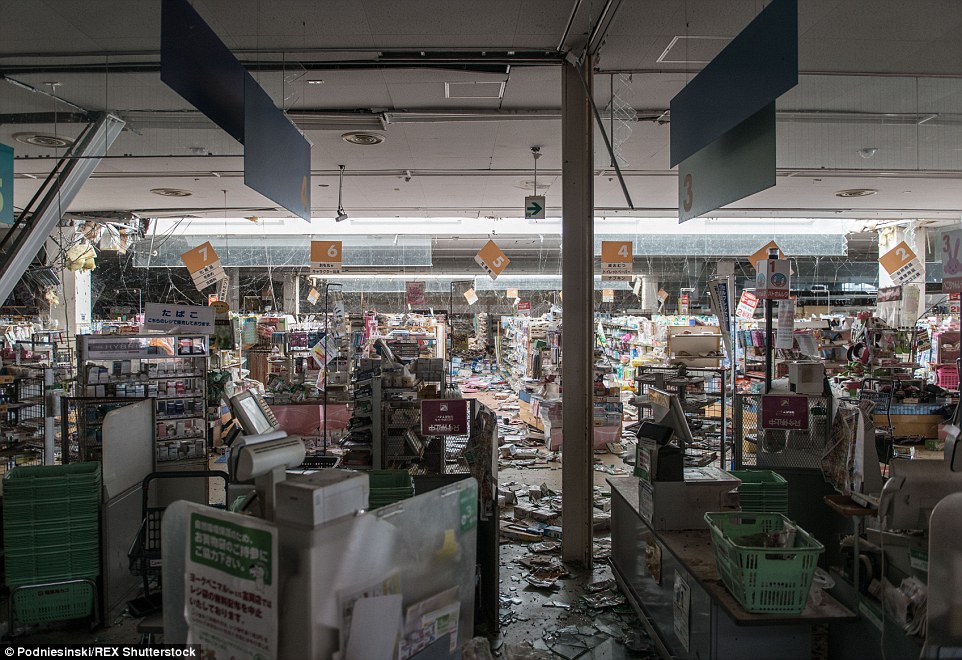 Supermarket checkouts and products lie strewn over the floor in this eerie image taken of a shop located near the Fukushima power plant