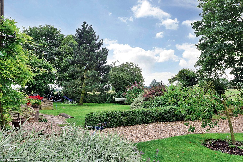 Colourful: The landscaped grounds have a mixture of mature trees and planted beds, with stone wall and fenced boundaries