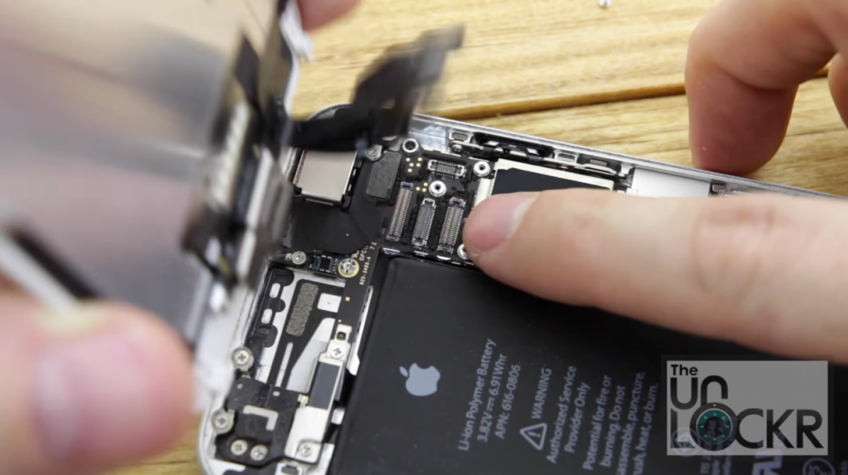 More parts are unscrewed and shimmied loose until the iPhone's screen is completely off.