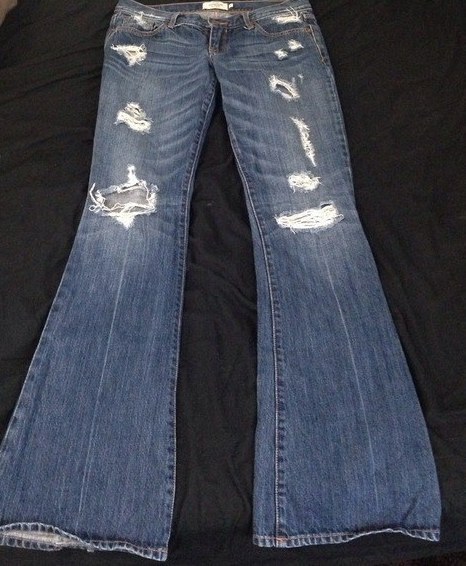 Distressed flared denim jeans, preferably from Abercrombie or Hollister.