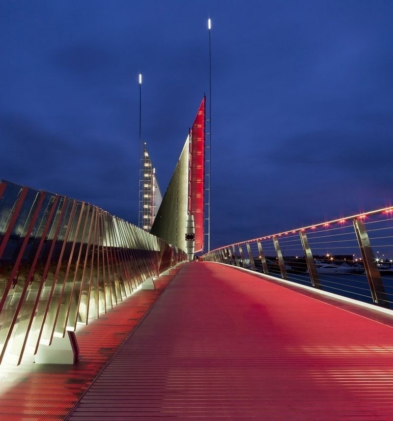 The pedestrian walkway is lit in bright red while the sails are white. 