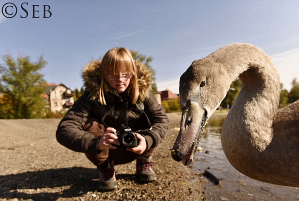 Mr Luczywo's portrait of Kaja crouched down with a swan during one of their many outings 