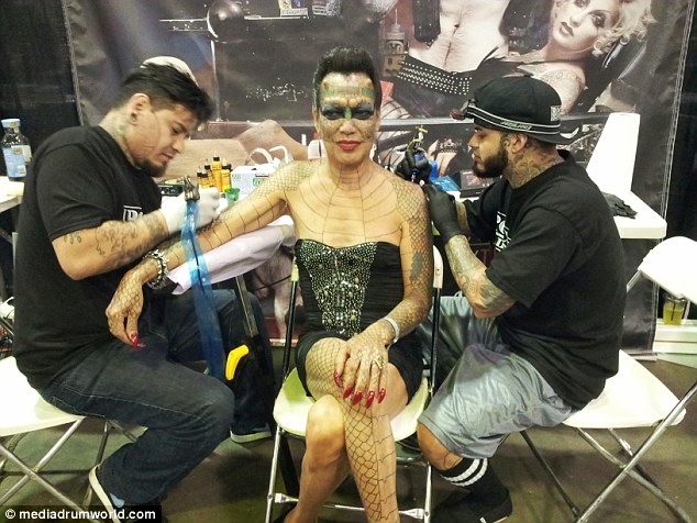 Tiamat with her 'Metamorphosis Team' tattoo artists, Rick Moreno (right) and Drew De la Fuente (left) at the New York Tattoo Convention. Her 'horns' are visible on her forehead but her ears and nose are still intact