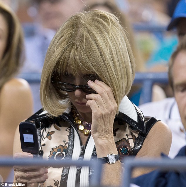 Old-fashioned: In between cheering on players at the U.S. Open on Thursday, Vogue editor-in-chief Anna Wintour was pictured glancing at her cell phone - a rather dated looking flip phone