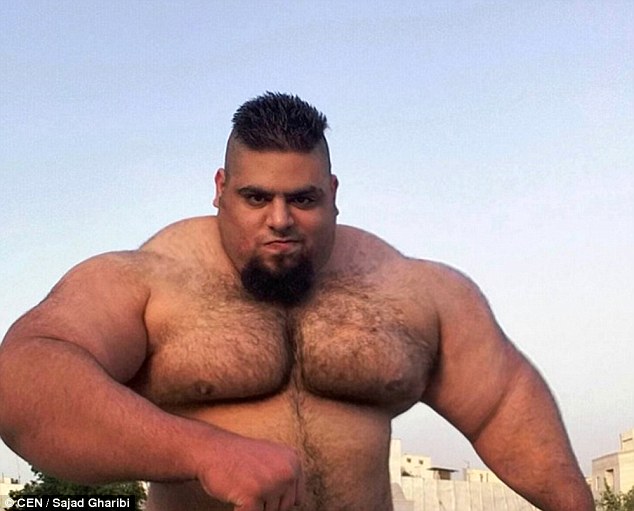 Enormous:  Sajad Gharibi, 24, poses topless on a rooftop to show off his incredible size in preparation to fight extremists