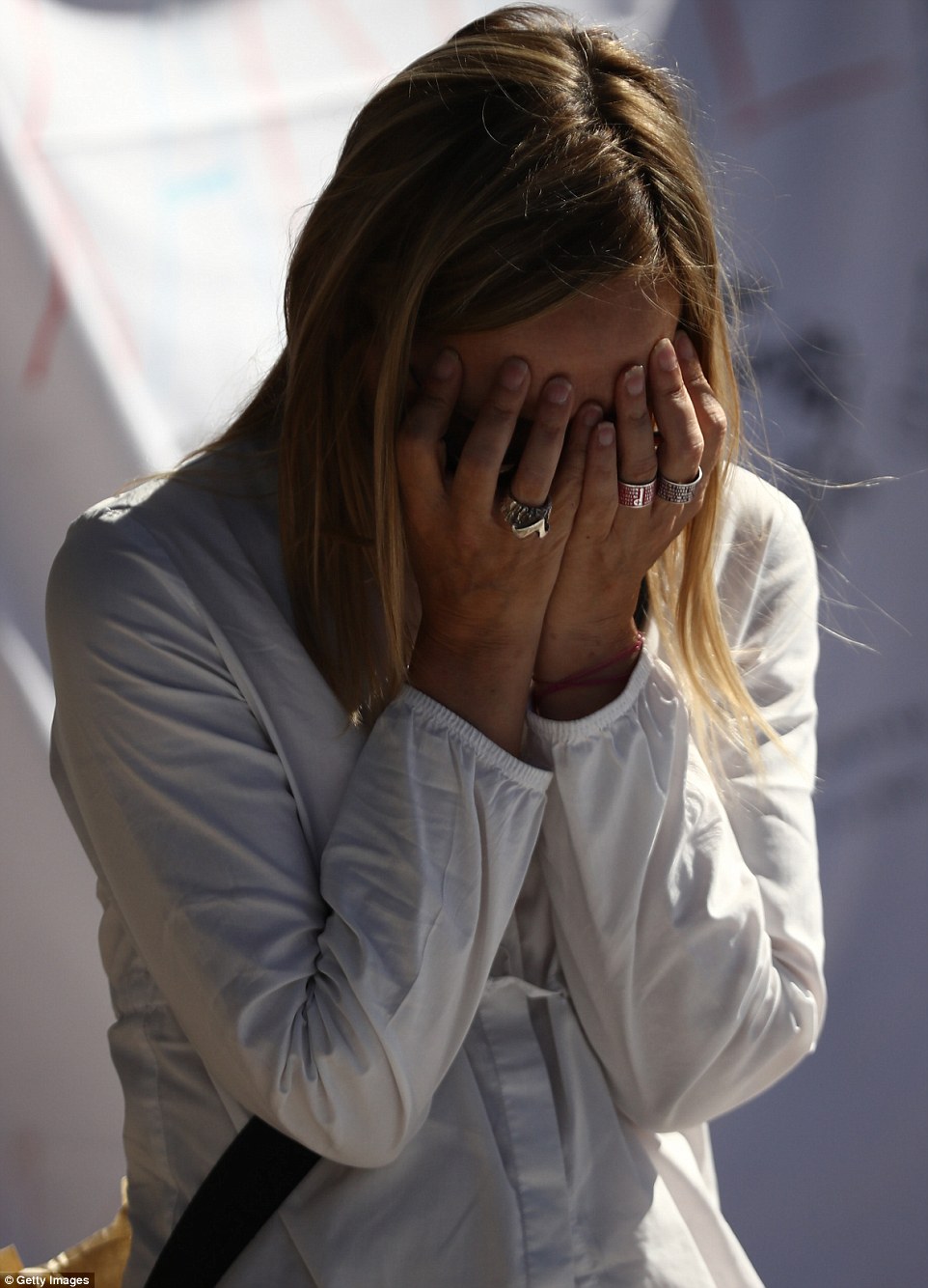 A woman holds her head in her hands as she weeps over a memorial to the victims in Nice, France following the atrocity