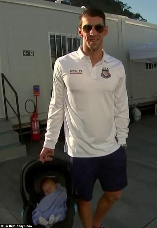 Bundle of joy: Phelps and Johnson welcomed their son Boomer in May, and Phelps was seen carrying the baby on Monday (above) as he arrived for his interview