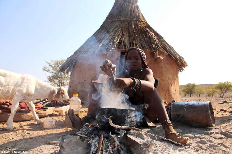 A young member of the Himba tribe cooking in the breathtaking rural surroundings of Namibia