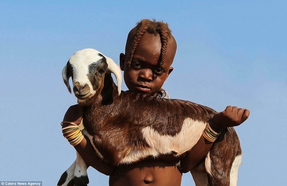 A young boy with a baby goat, taken by Swedish photographer Bjorn Persson in Namibia