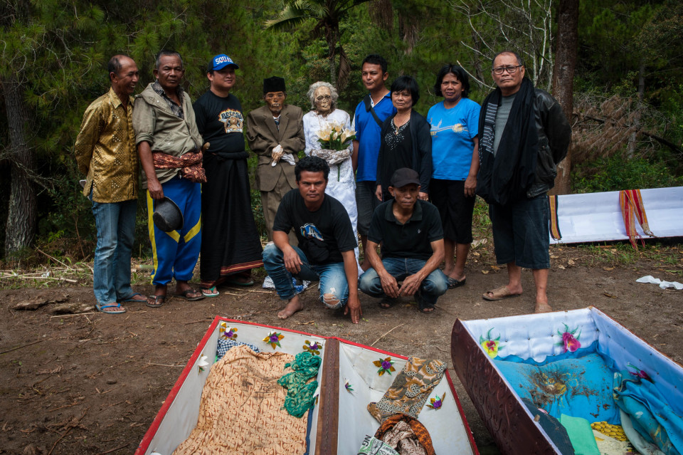 The family pose with their dead relatives during Ceremony of Cleaning Corpses
