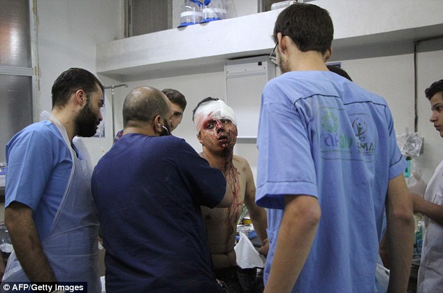 Bloodbath: An injured Syrian man receives treatment after the air strike on Idlib. Numerous doctors and nurses and medical facilities have been hit or targeted in recent weeks