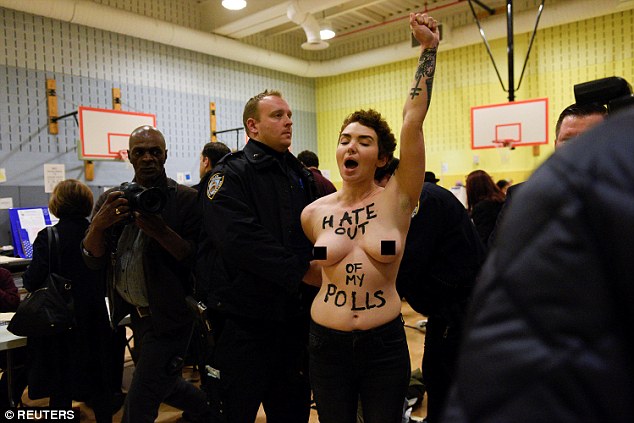 The anti-Trump slogan, along with, 'Hate out of my polls', was painted across their bare chests
