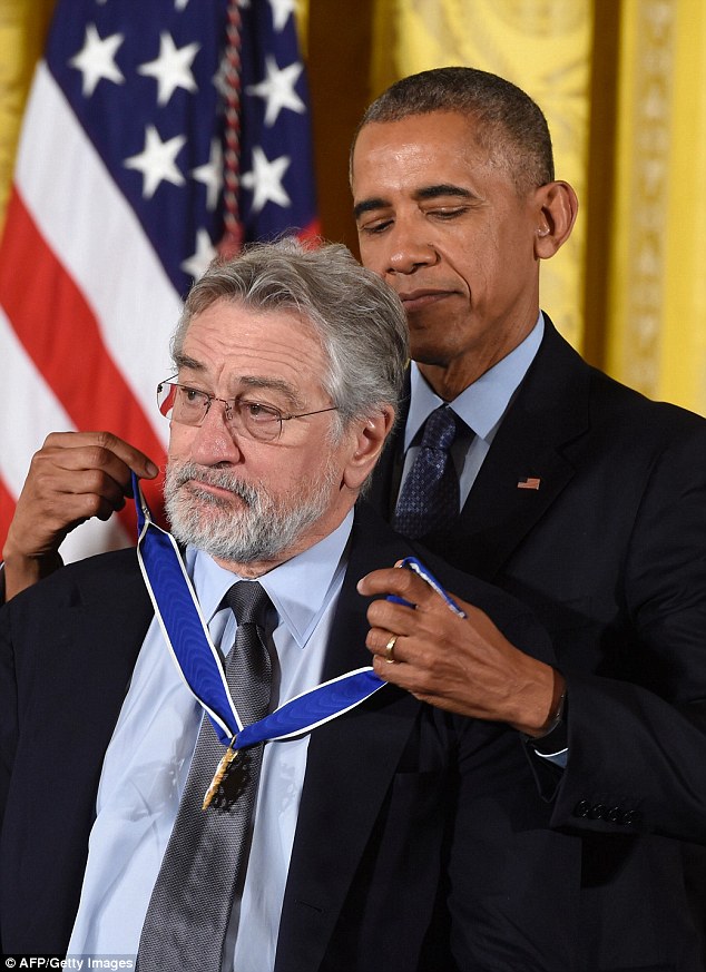 President Obama puts the Presidential Medal of Freedom over the head of Actor Robert De Niro, who he joked around with about the many mobster roles he had played 