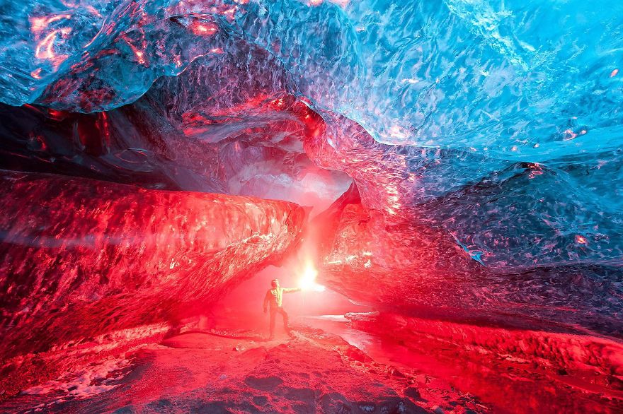 An ice cave in Iceland lit up with a flare